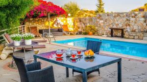 a patio with a table and chairs next to a pool at Amoroza Villa in Pissouri