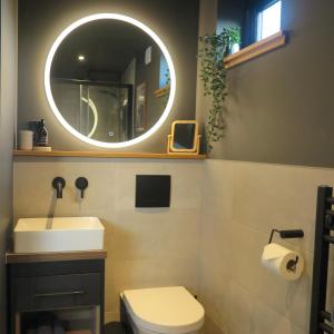 La salle de bains est pourvue d'un lavabo et d'un miroir. dans l'établissement Angusfield Cabins, à Sconser