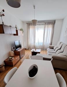 a living room with a white table and a couch at El Rincón del Pisuerga con Terraza in Cabezón de Pisuerga