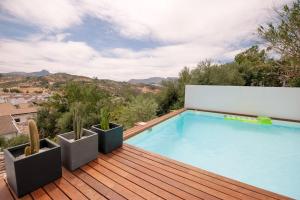 una piscina en la parte superior de una terraza de madera con cactus en Casita avec superbe vue et piscine privée en Algodonales