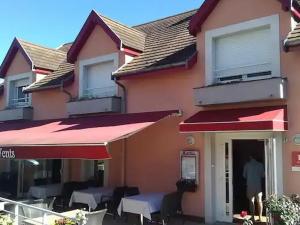 una casa con mesas y sillas frente a ella en L'Atelier Obelix familiale de 1 à 4 personnes en Saint-Symphorien-de-Marmagne