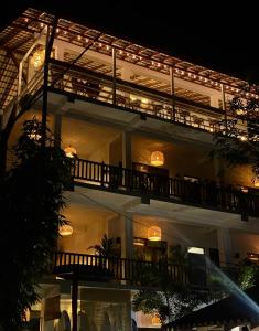 a large building with a balcony at night at Lucky's Surf Camp in Weligama