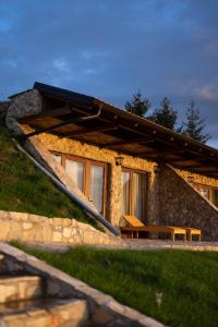 una casa de piedra con un banco delante en Zemunice Knezevic, en Banja Luka