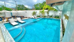 uma grande piscina com cadeiras e uma mesa em Pousada Aquino Mar em Paraty