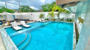 a large swimming pool with chairs and a table at Pousada Aquino Mar in Paraty