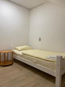 two beds in a white room with a table at Ruhige 4 Zimmer OG-Wohnung Z2 in Königsbronn
