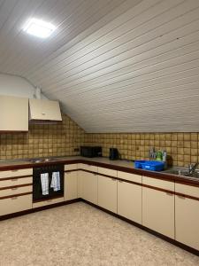 a kitchen with white cabinets and a sink at Ruhige 4 Zimmer OG-Wohnung Z2 in Königsbronn