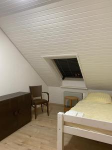 una camera con un letto e una sedia di Ruhige 4 Zimmer OG-Wohnung Z2 a Königsbronn