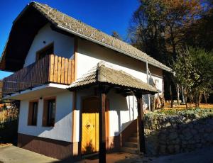 uma pequena casa com uma porta de madeira e uma varanda em Hiška sončni hrib. em Novo Mesto