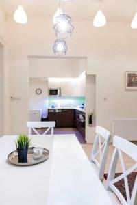 a kitchen and dining room with a white table and chairs at Sweet Relax House in Budapest +20 photos