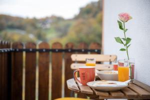 uma mesa de madeira com um vaso com uma rosa em Hiška sončni hrib. em Novo Mesto