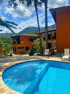 a large swimming pool in front of a house at Pousada Aquarela Maresias in Maresias