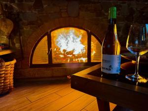 a bottle of wine sitting on a table next to a fireplace at A curuxa casa rural in El Mazo +20 photos