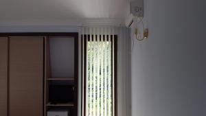 a window with a curtain in a room at Lasha Guest House in Makhinjauri