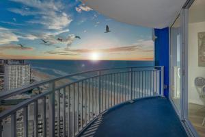a balcony with a view of the ocean and birds at On the Beach-2/Br 2/Bath, 26th floor! Spectacular views of Ocean & River in Daytona Beach Shores