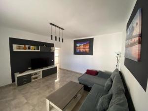 ein Wohnzimmer mit einem Sofa und einem TV in der Unterkunft Casa Niky 25 in Puerto del Rosario