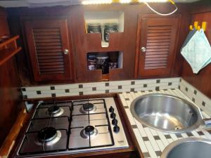 a kitchen with a stove top and a sink at Barca a Vela Principessa in Porto Carollo +36 photos