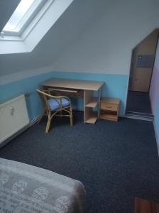 Cette chambre comprend un bureau, une chaise et un lit. dans l'établissement Kleine gemütliche Wohnung, à Zwickau
