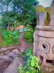 een stenen standbeeld in een tuin met enkele planten bij Raindance in Santa Cruz