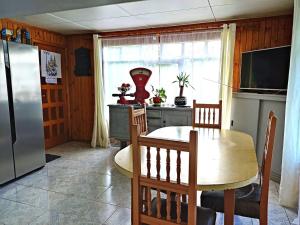 a kitchen with a table and a refrigerator at Hospedaje Martita. in Putemún