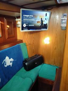 a room with a couch and a flat screen tv at Barca a Vela Principessa in Porto Carollo