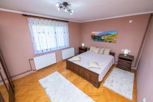 a bedroom with a bed and two rugs at FamilyApartment in Kolašin