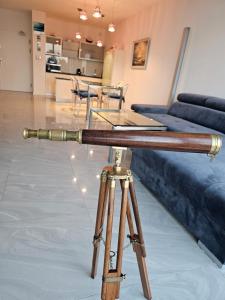 a telescope in a living room with a table at BLUE MORNING - nowoczesny apartament z widokiem na morze PLAYA BALTIS in Międzyzdroje
