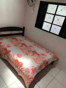 una camera da letto con un letto con un piumone floreale di Chácara Martins a Olímpia Altre 24 foto