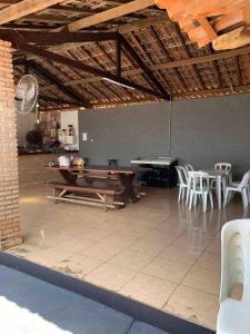 una stanza con tavolo da ping pong e sedie di Chácara Martins a Olímpia