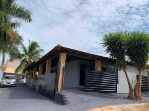 a building with a gate and palm trees at Chácara Martins in Olímpia