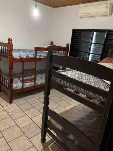 2 letti a castello in una camera con pavimento piastrellato di Chácara Martins a Olímpia