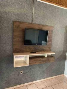 una TV a schermo piatto su una parete di legno di Chácara Martins a Olímpia