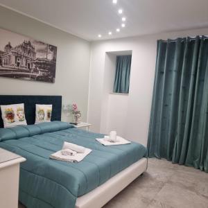 a bedroom with a blue bed with green curtains at Al Punto Giusto in Catania