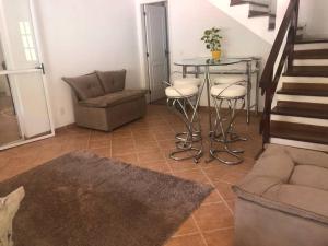 a living room with a table and chairs and a staircase at Casa em Teresopolis in Teresópolis