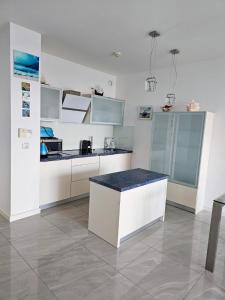 een keuken met witte kasten en een aanrecht bij BLUE MORNING - nowoczesny apartament z widokiem na morze PLAYA BALTIS in Międzyzdroje
