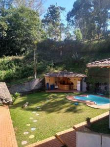 a backyard with a swimming pool and a house at Casa em Teresopolis in Teresópolis