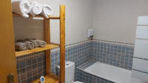 a blue tiled bathroom with a tub and a toilet at El Nido de Candeleda in Candeleda