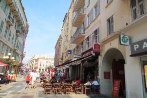 a group of people sitting at tables in a street at Intérieurs-Cour in Nice