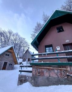 a house with snow on the ground next to it at Vila Darija in Žabljak