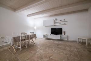 MarGa's House في باري: غرفة معيشة بيضاء مع طاولة وتلفزيون