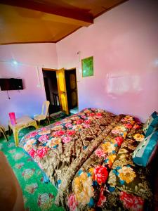 1 dormitorio con 1 cama con una manta colorida en Al Hayat Guest House, en Pahalgām