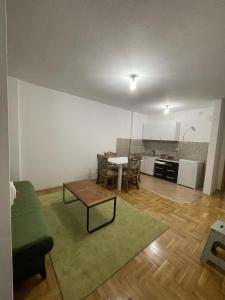 Kosovo Polje的住宿－Erion’s apartament，一间带桌子的客厅和一间厨房
