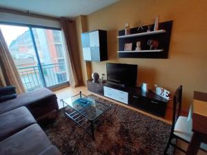 a living room with a couch and a flat screen tv at APARTAMENTO CANELAS in Portonovo