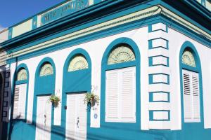 un edificio azul y blanco con ventanas y puertas en City Dreams Cozy Loft in Guayama Great Location, en Guayama