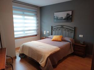 a bedroom with a bed and a window at APARTAMENTO CANELAS in Portonovo