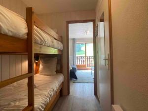 a bedroom with two bunk beds and a balcony at Cozy studio between the lake and the mountain in Le Biot