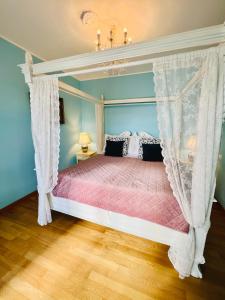 a bedroom with a canopy bed with a pink comforter at Esmaraldas House of Love in Terrasini