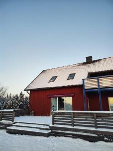 a red barn with snow on the ground in front of it at Kivika in Lahe