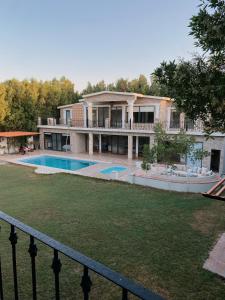 una casa grande con un patio con piscina en منتجع بيت الريف, en Al Hofuf