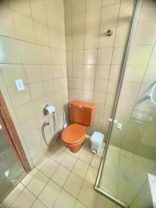 een badkamer met een oranje toilet en een douche bij Apto Centro Moderno e Completo in Ribeirão Preto +15 foto's